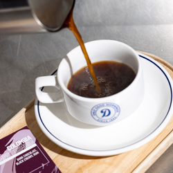 A closeup of plunger coffee being poured into a mug