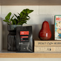 Limited release Coffee blend for RTRFM sitting on wooden shelf next to books