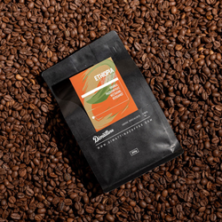 A bag of Dimattina Single Origin coffee from Ethiopia laying on a bed of freshly roasted beans