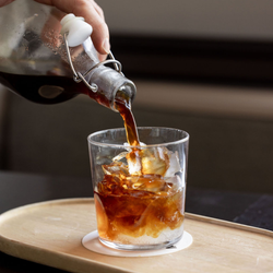 Pouring cold brew coffee into a glass with ice