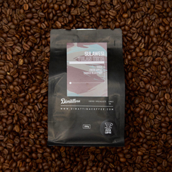 A bag of Yolan Tirta coffee on a pile of coffee beans