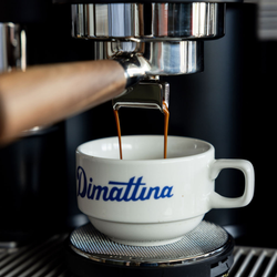 A close up of espresso pouring into a Dimattina cup
